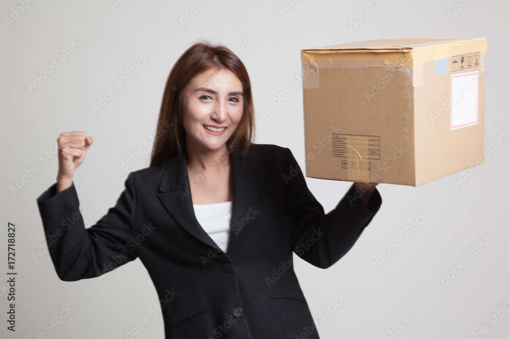 Young Asian working woman flex bicep with shipping box Young Asian working woman flex bicep with shipping box