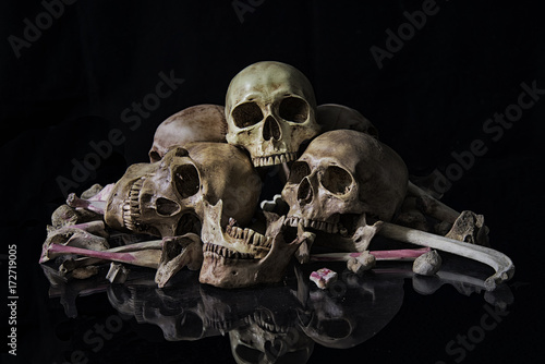 The human skull and pile of bones on black background, Halloween night, Still life style, art. photo