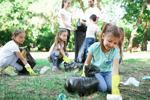 Fotografie Young volunteers and children collecting garbage in park