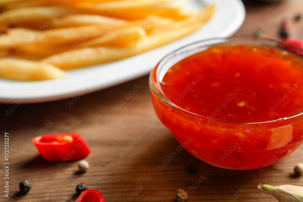 Glass bowl with chili sauce on kitchen table Glass bowl with chili sauce on kitchen table
