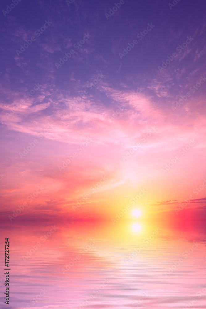 Obraz premium Fioletowy zachód słońca z dużym słońcem z niewielką ilością chmur nad morzem.