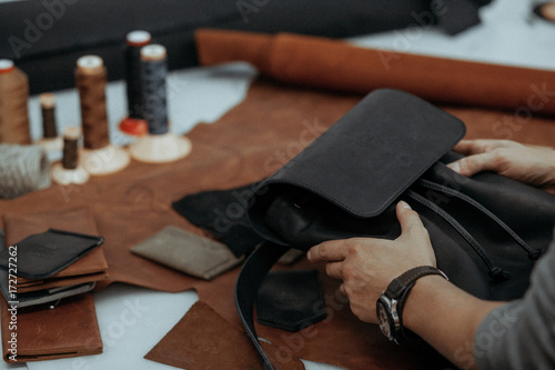 The master makes a leather bag. A close up, a product from skin in hands.