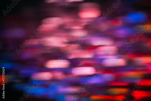 Abstract background of colorful blurs in motion on black. Bokeh of defocused streaks, blurred neon blue, orange and red leds, glowing city lights, wallpapers and banners © golubovy