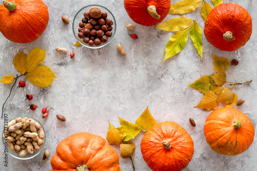 Pumpkin harvest. Pumpkins near nuts and autumn leaves on grey background top view copyspace photo