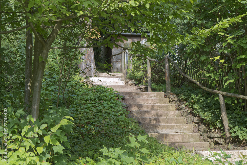 Old stone staircase with a rotten, wooden handrail on the background of the brake. Old stone staircase with a rotten, wooden handrail on the background of the brake.