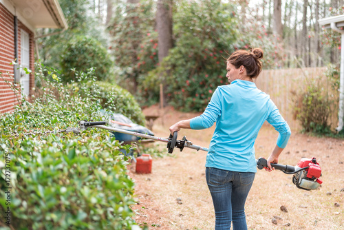 Woman using hedge trimmers outside