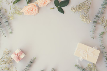 gift or present box and flowers on blue table from above, flat lay frame, retro toned