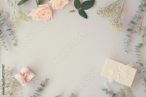 Photography gift or present box and flowers on blue table from above, flat lay frame, retro
