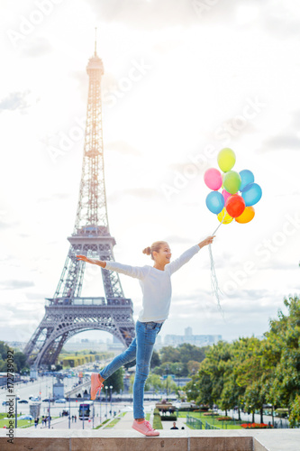 Girl with bunch of colorful balloons in Paris near the Eiffel tower. © Max Topchii