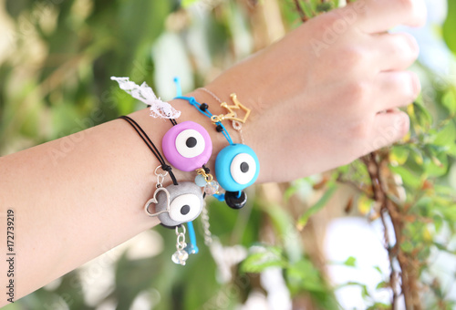 woman hand wearing colorful evil eye bracelets - greek jewelry advertisement