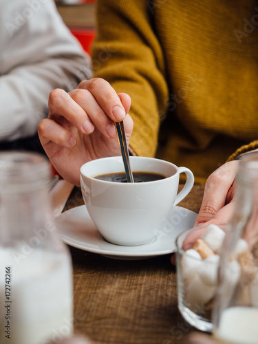 Girl stirring her coffee
