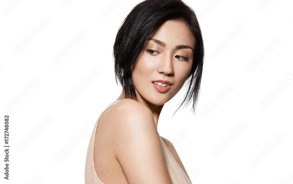 Obraz premium Beautiful young brunette woman in beige dress with clean skin and natural make-up looks to the left side isolated on white background