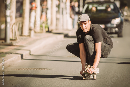 Skateboarder ride a skateboard slope through the city street © guruXOX