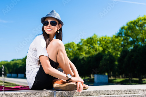 Young Asian woman smiling while looking away in a summer day in the park