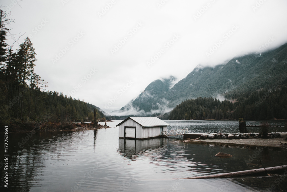 lake boat house surrounded by fog and trees lake boat house surrounded by fog and trees