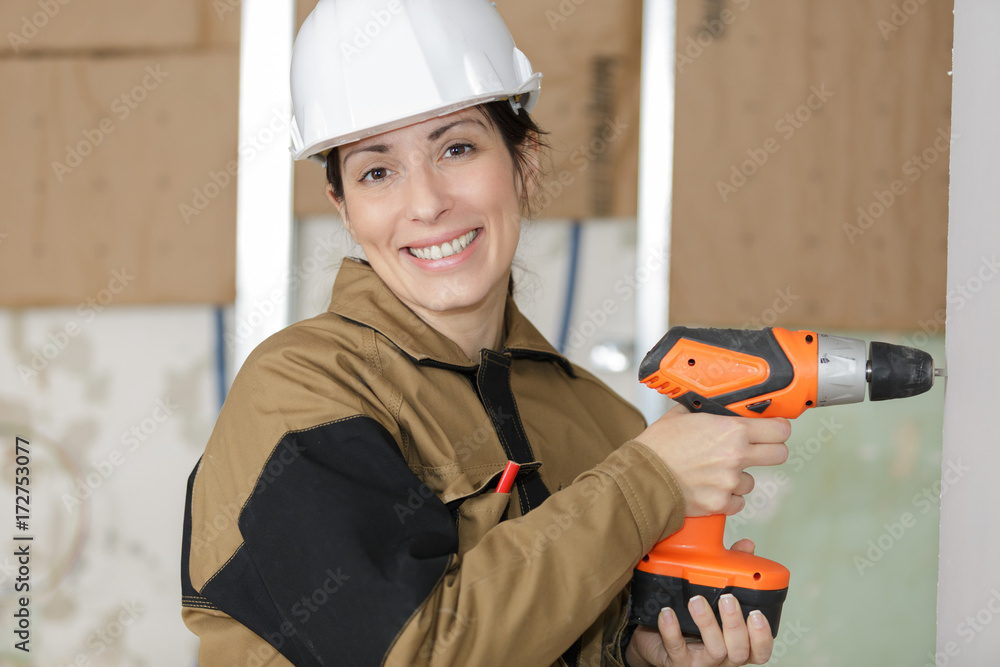 woman builder drilling on the wall woman builder drilling on the wall