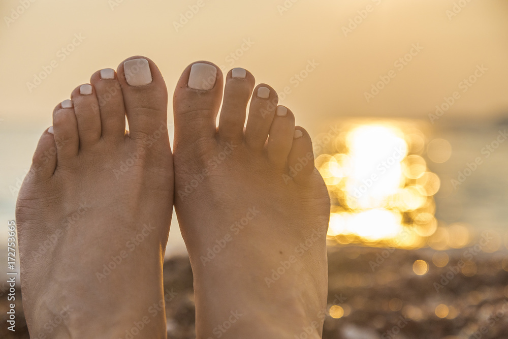 ноги с красивым педикюром на фоне закатного моря Stock-Foto | Adobe Stock