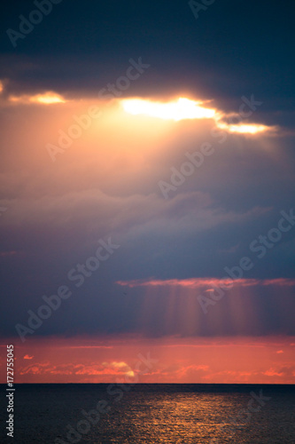 Rays of sun through the clouds over the sea photo
