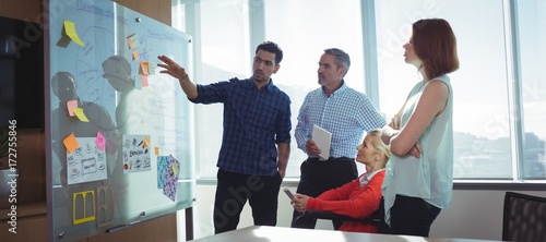 Photos Young businessman discussing with colleagues at office