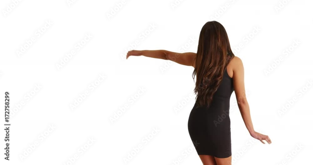 Rear view of beautiful Cuban woman in tight black dress dancing on white background with copyspace. Slow motion shot of Latina female having fun, dancing in studio with copy space. 4k Rear view of beautiful Cuban woman in tight black dress dancing on white background with copyspace. Slow motion shot of Latina female having fun, dancing in studio with copy space. 4k