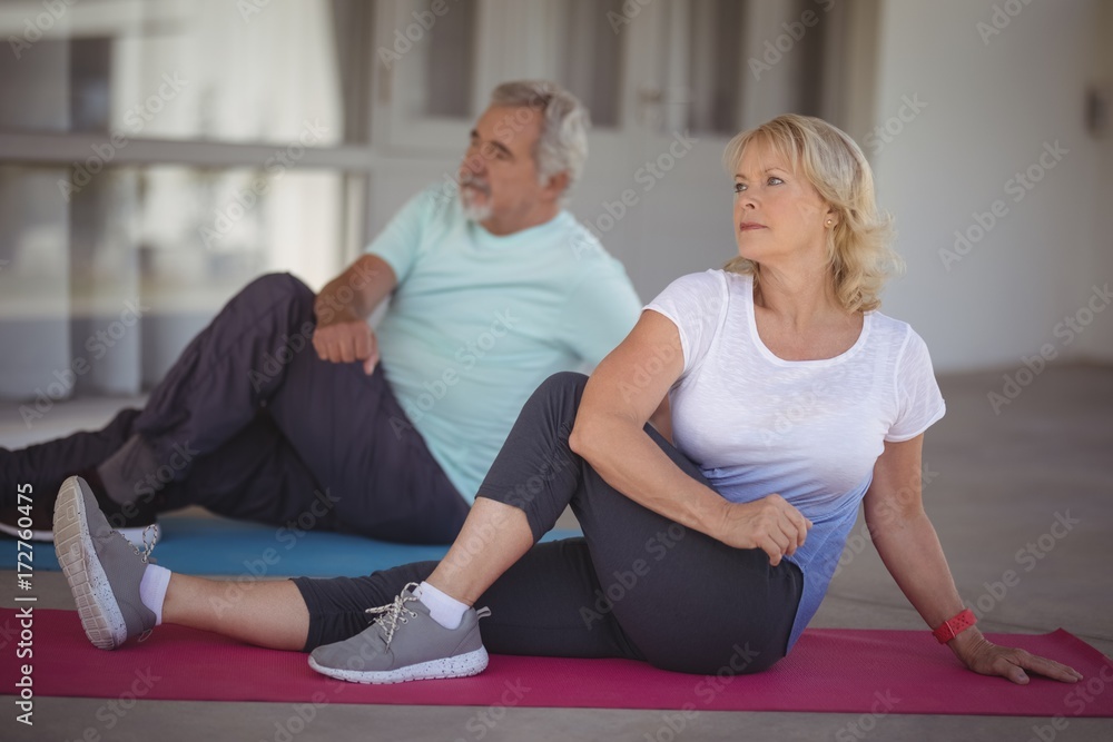 Senior couple performing stretching exercise Senior couple performing stretching exercise