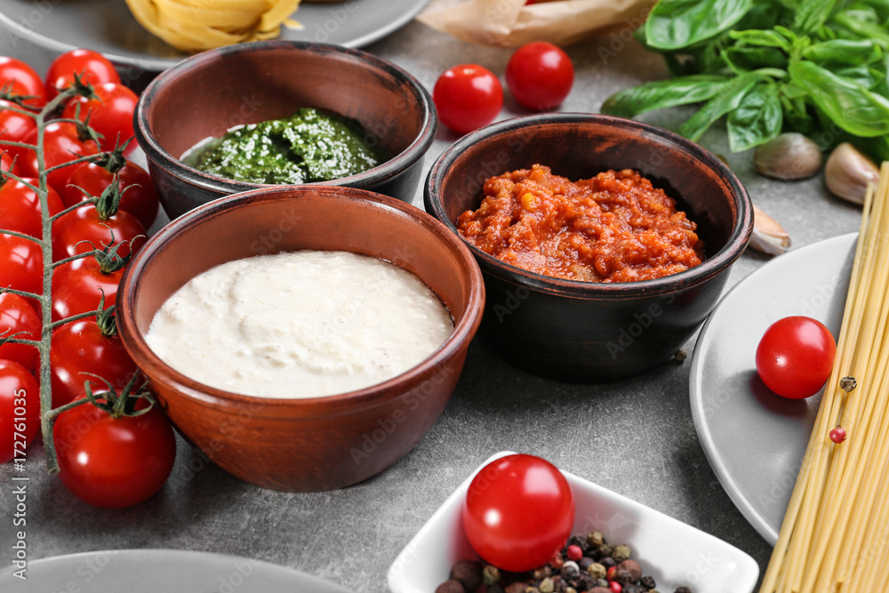 Delicious pesto, bolognese and white sauces for pasta in bowls on table Delicious pesto, bolognese and white sauces for pasta in bowls on table