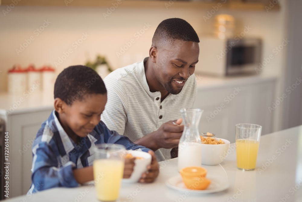 Father and son having breakfast in kitchen Father and son having breakfast in kitchen
