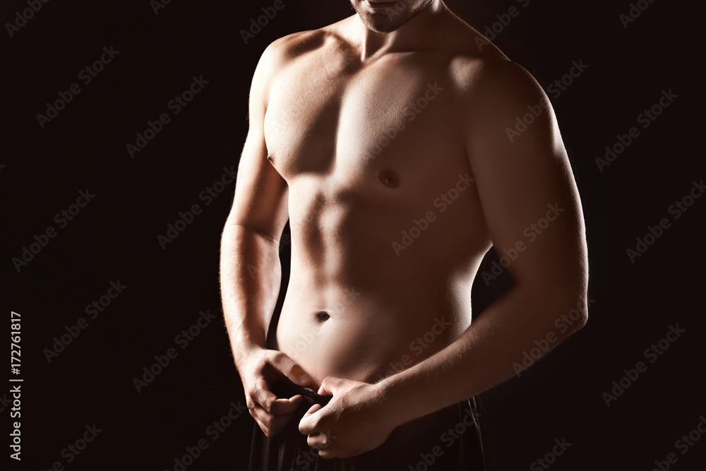 Fototapeta premium Sporty young man on dark background