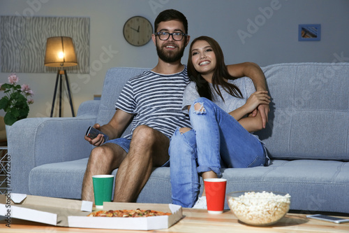 Young couple watching TV in...