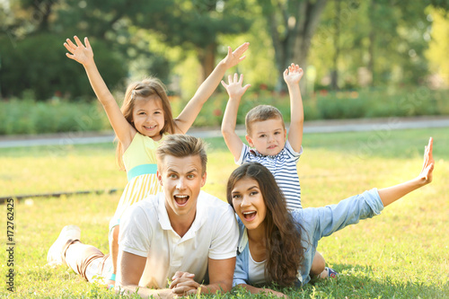 Happy family lying on grass in park © Africa Studio