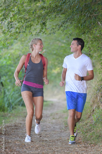 healthy fit sportive couple running in nature