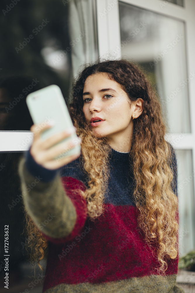 Lovely woman makes duck face while taking a selfie with mobile phone Lovely woman makes duck face while taking a selfie with mobile phone