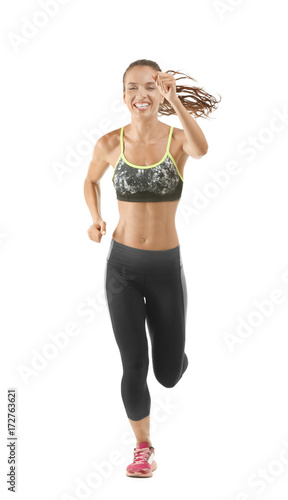 Beautiful young woman in sportswear running on white background © Africa Studio