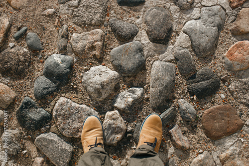 Beige male shoes on the cobblestone. POV picture. Top view photo