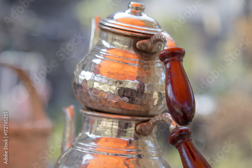 Traditional copper Turkish teapot in summer outdoor cafe. photo