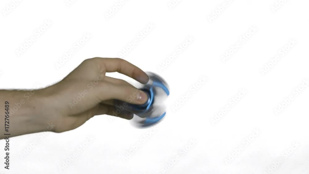 Playing with a fast blue fidget spinner in a turning hand.