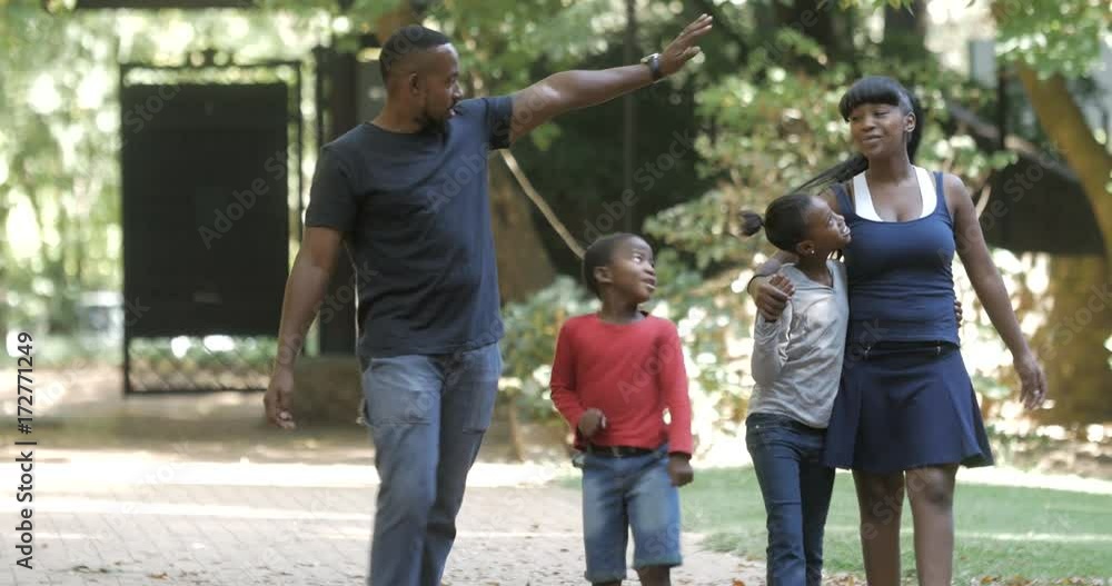 Happy African American family taking a walk & having fun outdoors in summer Happy African American family taking a walk & having fun outdoors in summer