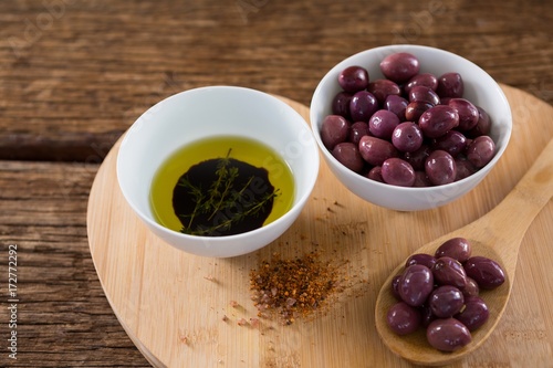 Purple olives  oil and wooden spoon on table