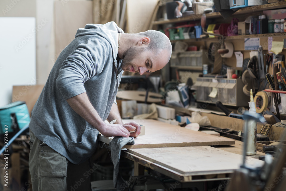 Young carpenter working on cabinet doors in a workshop Young carpenter working on cabinet doors in a workshop