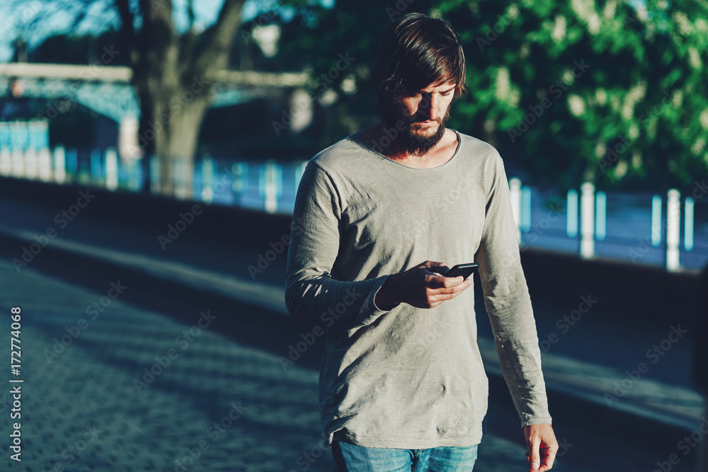 Fototapeta premium Hipster walks around the city with a phone.