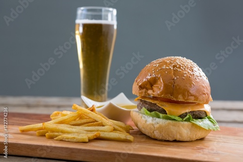 Close up of cheeseburger with french fries and beer glass