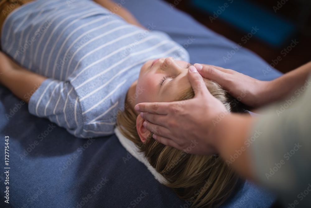 High angle view of female therapist giving head massage to boy High angle view of female therapist giving head massage to boy