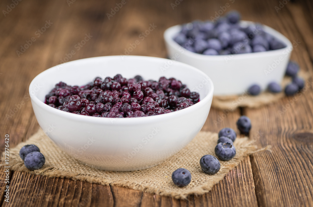 Portion of Blueberries (preserved) on wooden background, selective focus Portion of Blueberries (preserved) on wooden background, selective focus