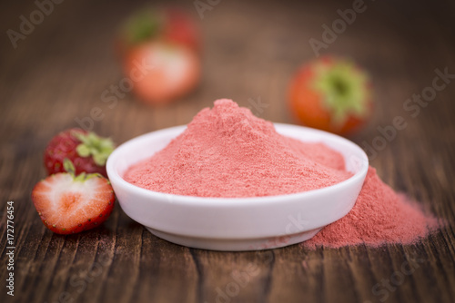 Strawberry powder on wooden background; selective focus