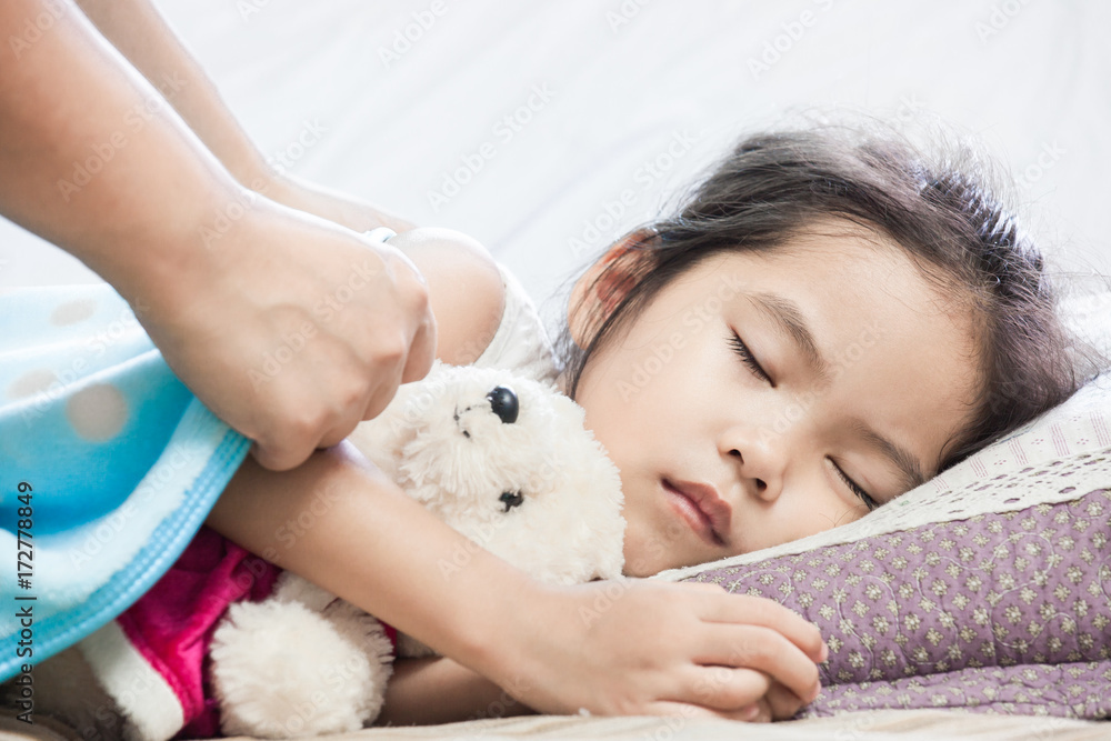 Mother taking care asian child girl while she sleeping in the bed Mother taking care asian child girl while she sleeping in the bed