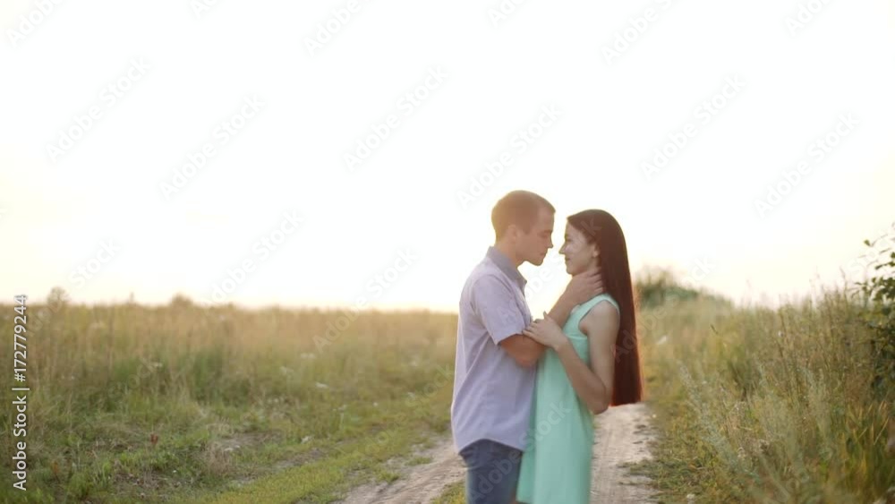 Walk in the field. The guy and the girl are standing in the field on the country road. Walk in the field. The guy and the girl are standing in the field on the country road.