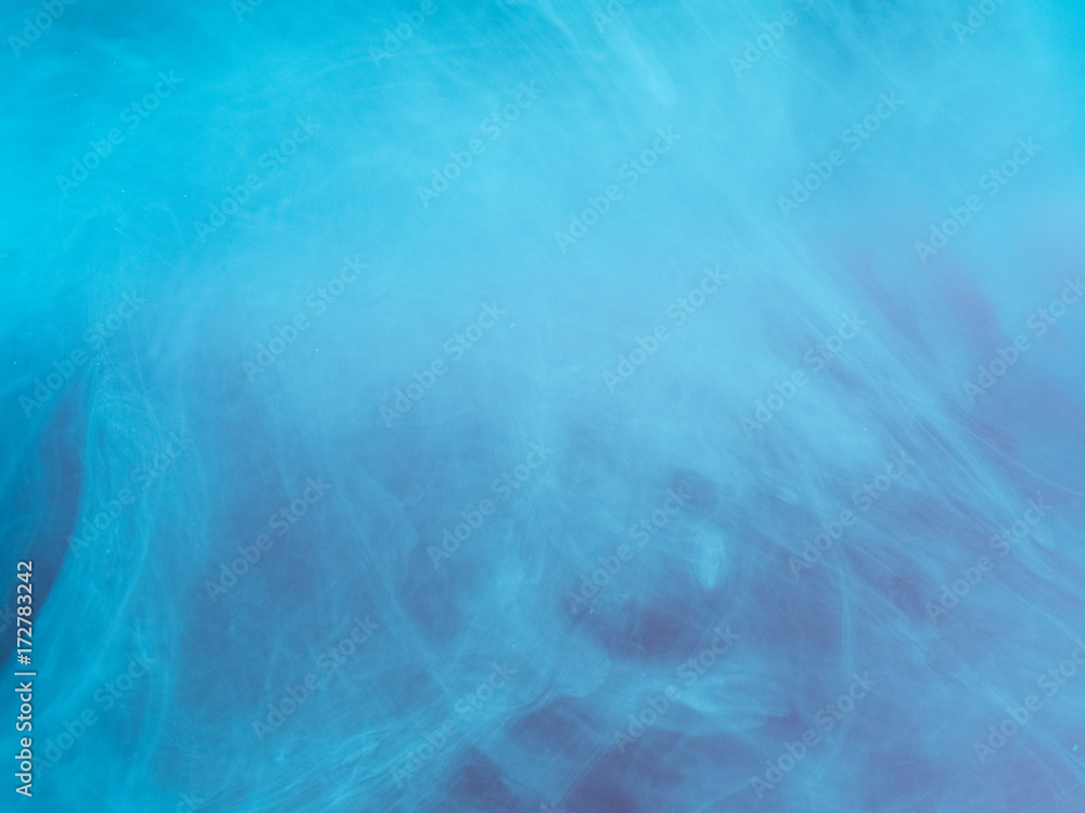 Abstract colored background. Blue smoke, ink in water, the patterns of the universe. Abstract movement, frozen multicolor flow of paint. Horizontal photo with soft focus, blurred backdrop.
