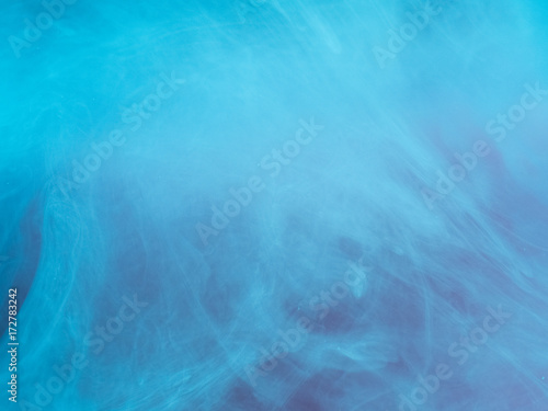 Abstract colored background. Blue smoke, ink in water, the patterns of the universe. Abstract movement, frozen multicolor flow of paint. Horizontal photo with soft focus, blurred backdrop.