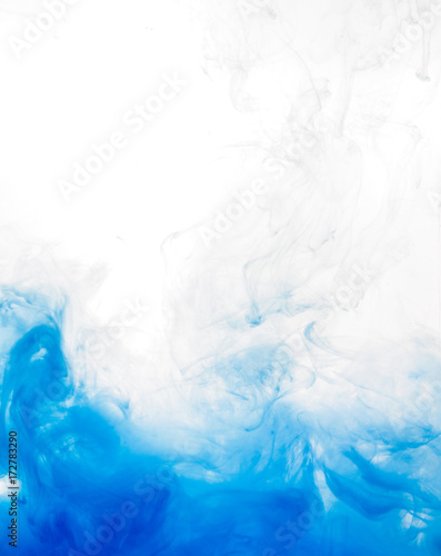 Ink swirl in water isolated on white background. The paint in the water. Soft dissemination a droplets of blue ink in water close-up. Abstract background. Soft focus.