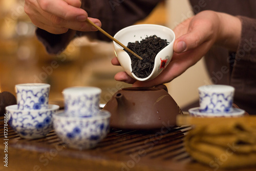 Photography Chahe with black tea for Chinese tea drinking in the hands of the master over the table